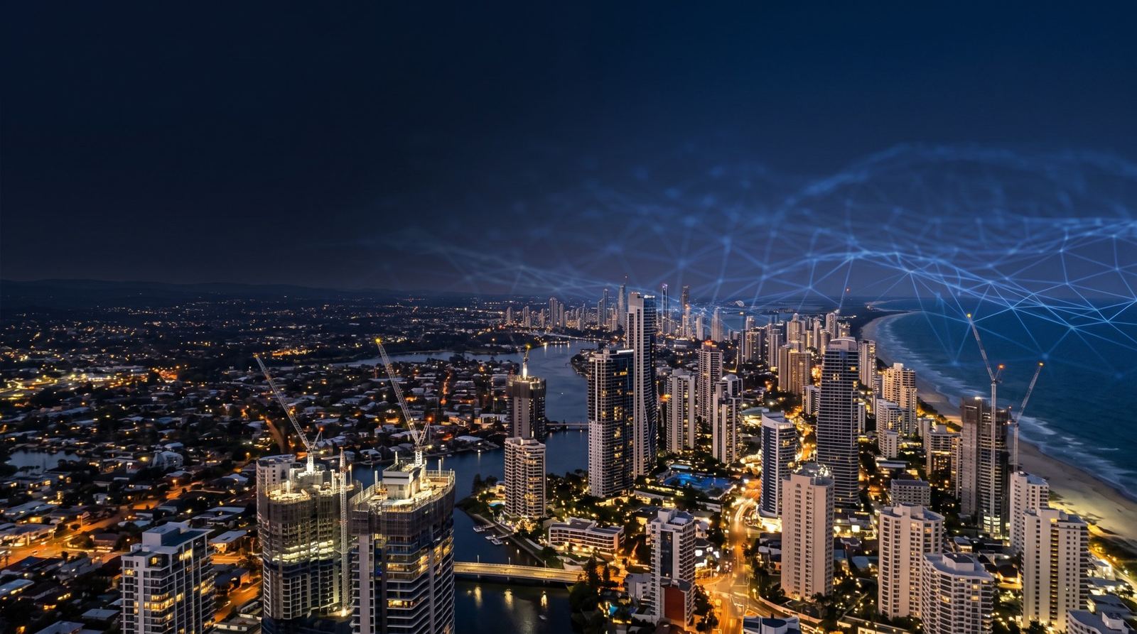Gold Coast skyline at night with tower cranes on residential high-rises